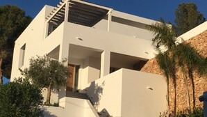 A modern two-story house with a staircase leading to the entrance, surrounded by greenery and a stone wall. - Villa Veintidos Large Luxury Villa Sleeps 12 (El Portet, Moraira)