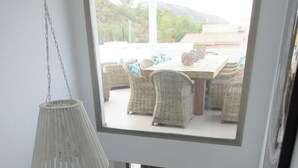 A staircase leading to a balcony with wicker furniture and a hanging light fixture. - Villa Veintidos Large Luxury Villa Sleeps 12 (El Portet, Moraira)