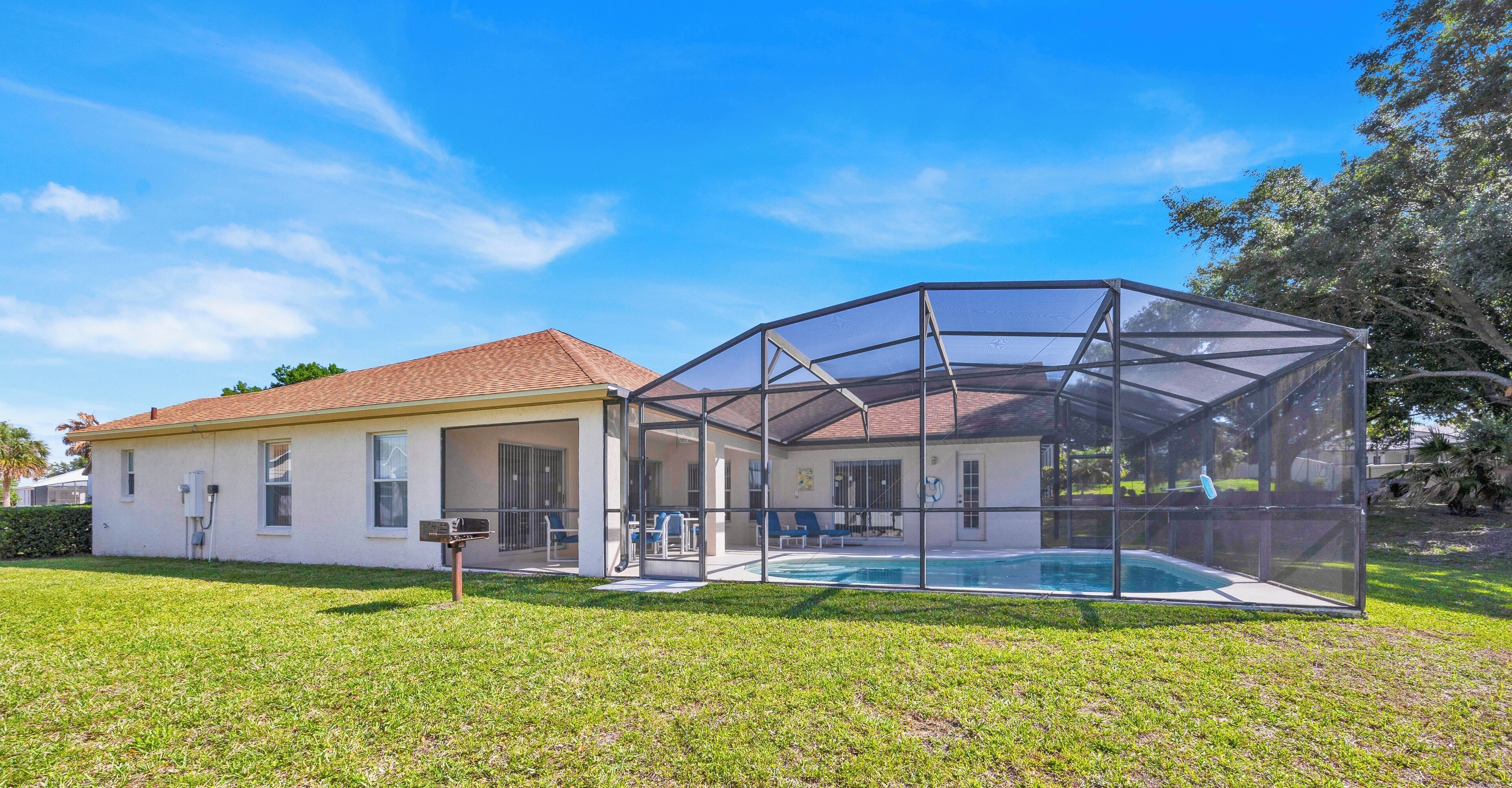 A house with a covered swimming pool and a large glass enclosure.