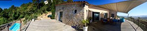 A stone building with a pool, outdoor seating, and a view of the hills. - Stunning home, pool, and terraces overlooking Porto Vecchio, with exceptional views (Porto-Vecchio)