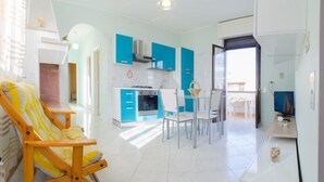 Een modern appartement met een keuken, een eetgedeelte en een woonkamer met een gestreepte stoel.