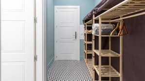 A narrow hallway with a white door, a patterned floor, and a bunk bed with wooden shelves against a teal wall. - BED AND BREAKFAST ONLY HUERTAS-2 (Madrid)