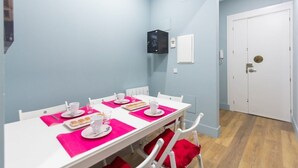 A dining area with a white table set for four, pink placemats, and white chairs. - BED AND BREAKFAST ONLY HUERTAS-2 (Madrid)