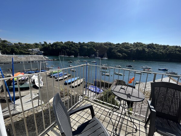 A terrace with outdoor seating, overlooking a marina with boats and a forested hillside. - Seasteps - Four Bedroom Cottage, Sleeps 8 (Fowey)
