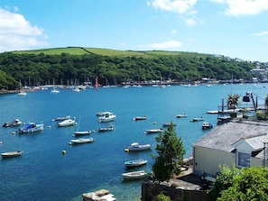 A coastal marina with boats docked, surrounded by greenery and hills. - Seasteps - Four Bedroom Cottage, Sleeps 8 (Fowey)