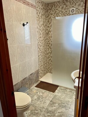 Tina con regadera, bidet, toallas, jabón 