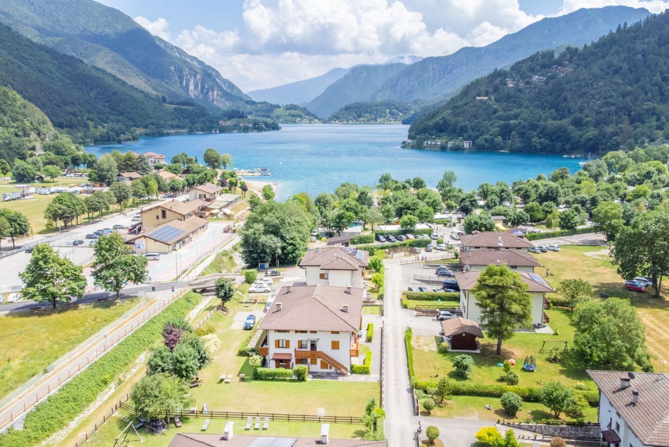A residential area with houses, a road, and a lake.