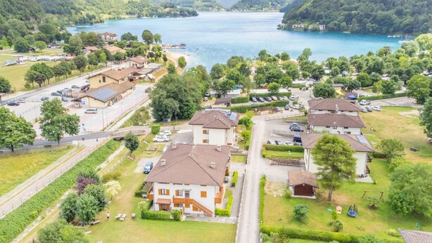 A residential area with houses, a road, and a lake.