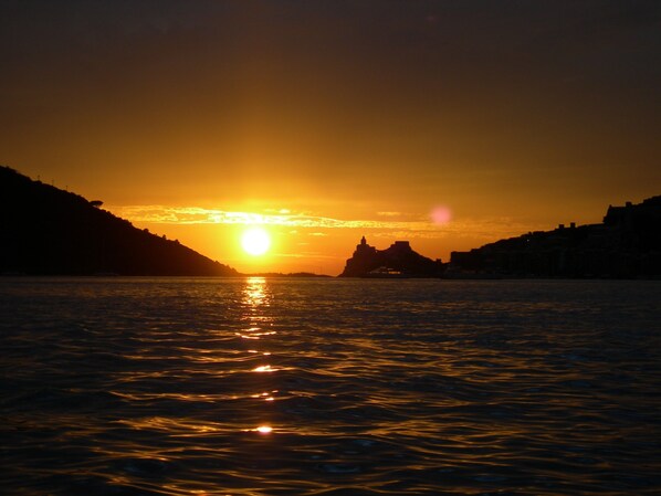 Experience a serene sunset over a tranquil body of water, with the sky reflecting off its surface.