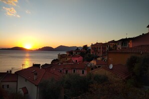 Experience the charm of a Mediterranean coastal town, where buildings with red-tiled roofs line the water's edge.