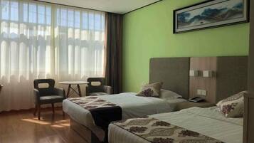 Una habitación de hotel con dos camas, un escritorio y una silla.
