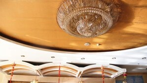 A ceiling with a large, ornate chandelier and multiple wall clocks. - Nongjun Hotel (Beijing)