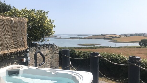 Un jacuzzi con vista a un lago y al paisaje circundante.