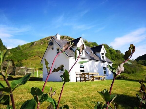 A white house with a sloped roof, a chimney, and a visible window. - Achalic Beag - sleeps 4 guests  in 2 bedrooms (Oban)