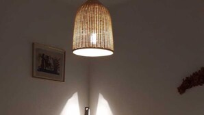 A room with two beds, a bedside table, a lamp, and a wall-mounted picture. - Residential flat with garden (Scarlino)