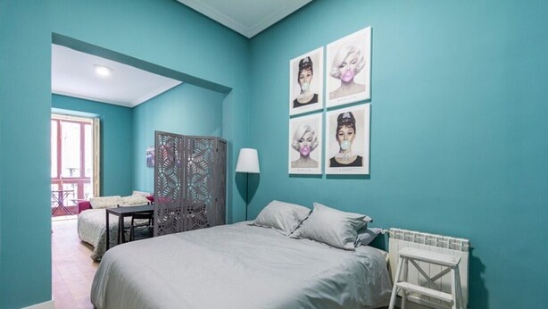 Une chambre à coucher avec un lit, un bureau, une chaise et une fenêtre.