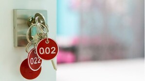 Un porte-clés avec deux clés attachées à un anneau, chaque clé étant munie d’une étiquette rouge portant le numéro « 002 ».