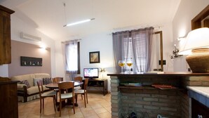 Una sala de estar acogedora con chimenea, comedor y televisor.