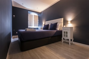 A modern bedroom with a large bed, bedside tables, and a window. - Apartment with a private terrace in Bairro Alto (Lisboa)