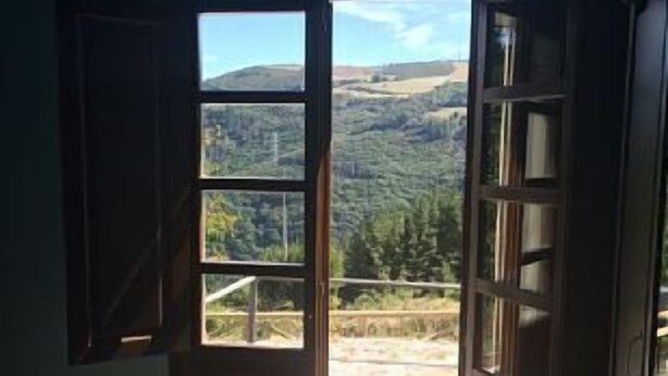 Une chambre à coucher avec un lit, une fenêtre et une vue sur un paysage montagneux.