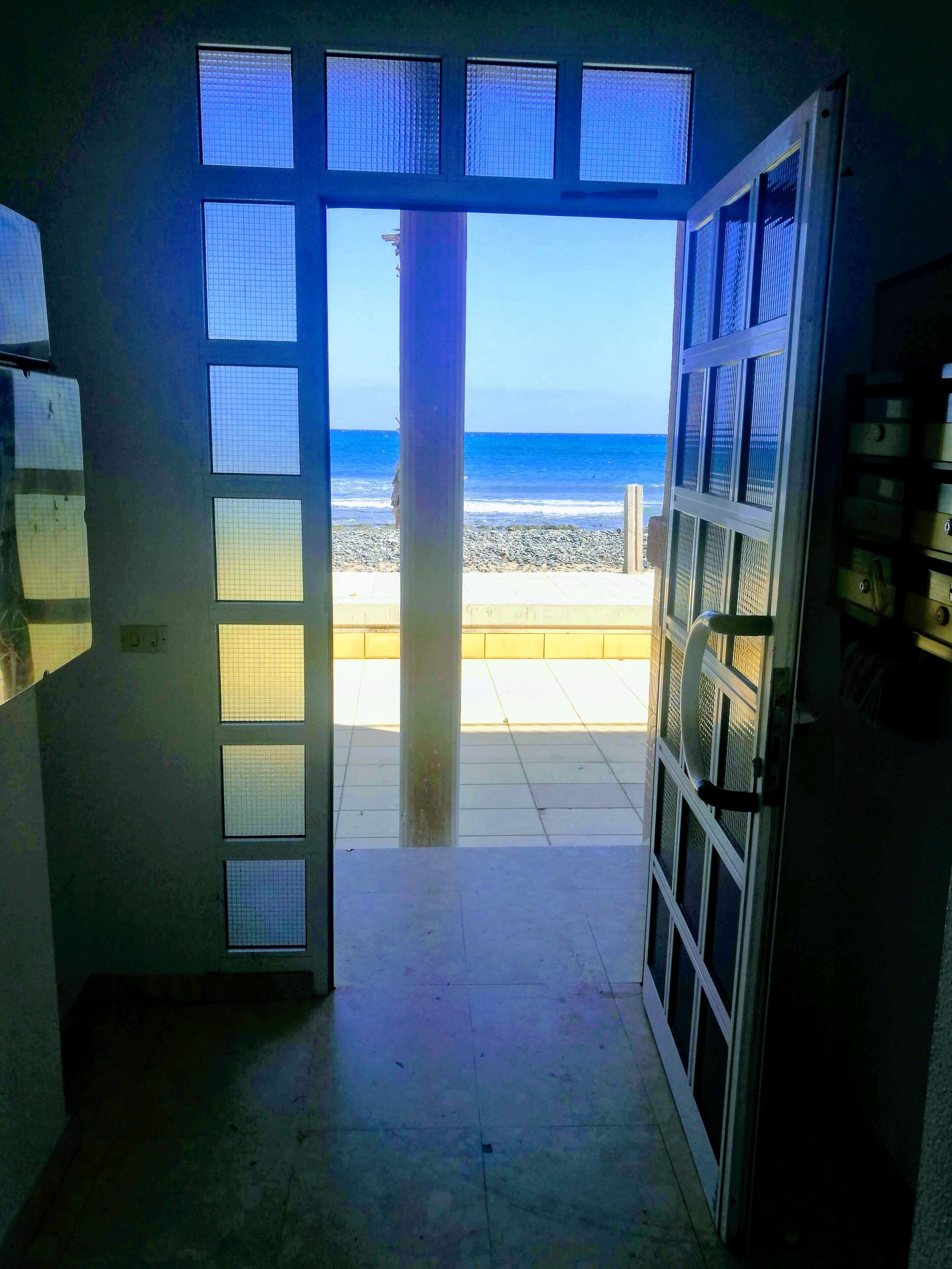 Une pièce dotée d’une grande fenêtre donnant sur une plage.