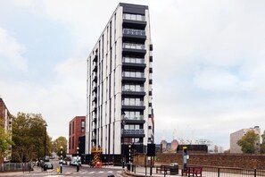 A modern high-rise building with multiple balconies and a prominent sign indicating its name. - Deluxe Victoria Home close to Buckingham Palace (London)