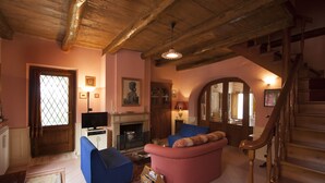 A cozy living room with a fireplace, a television, and a staircase. - detached house with garden, kitchen, laundry, bathroom with jacuzzi  (Decollatura)