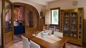 A dining area with a wooden table, chairs, a buffet cabinet, and a kitchen in the background. - detached house with garden, kitchen, laundry, bathroom with jacuzzi  (Decollatura)