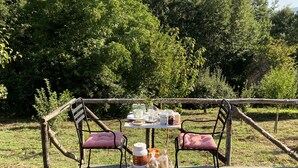 An outdoor dining area with a table set for two, surrounded by a rustic wooden fence. - detached house with garden, kitchen, laundry, bathroom with jacuzzi  (Decollatura)