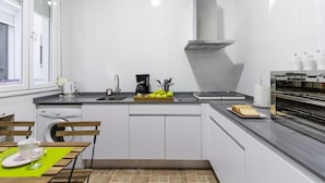 Een moderne keuken met een vaatwasser, koffiezetapparaat en oven.