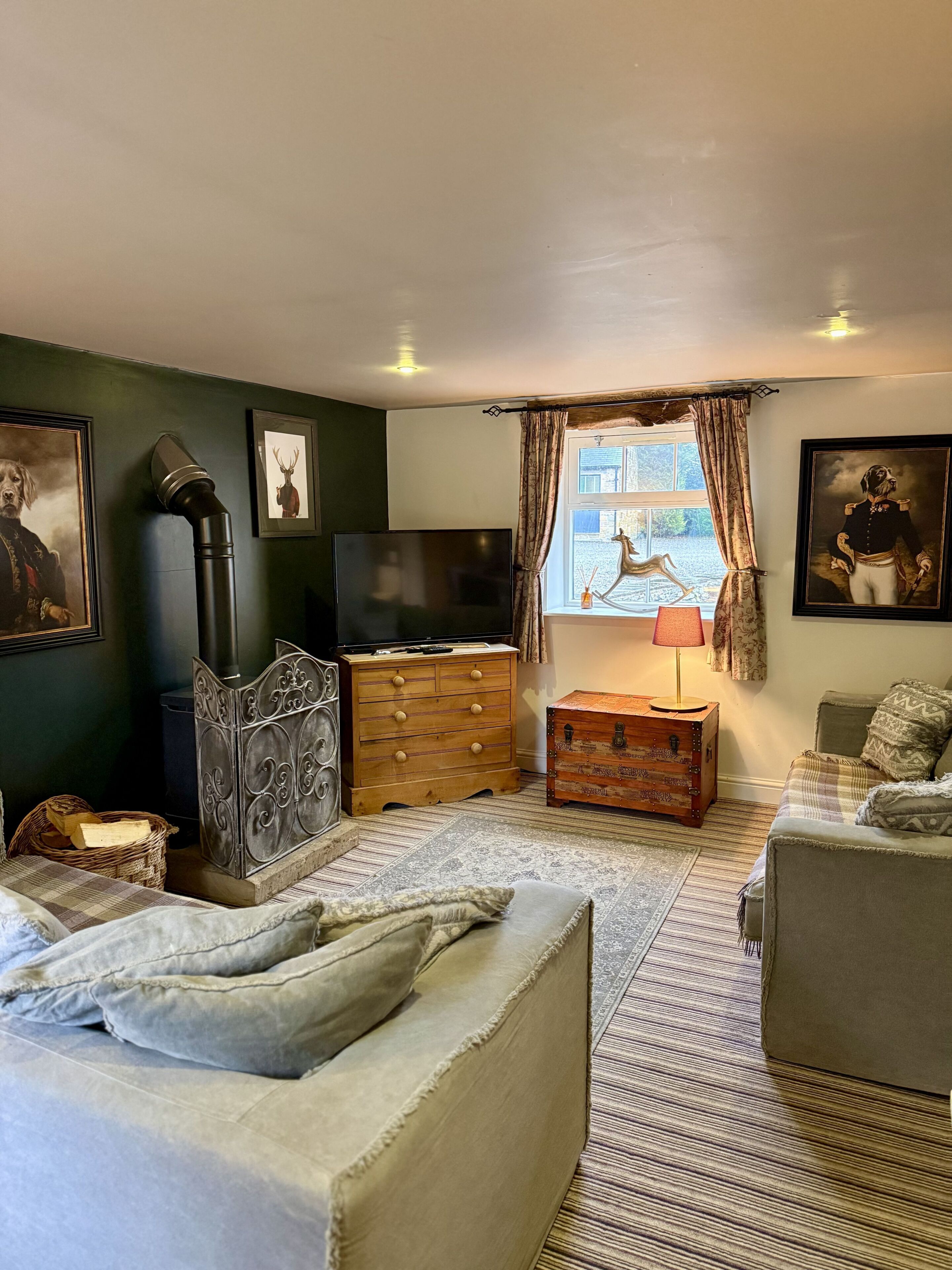 A cozy room with a bed, a dresser, a television, and a window with curtains.