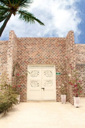 Un edificio de ladrillo con una puerta blanca y detalles decorativos tallados.