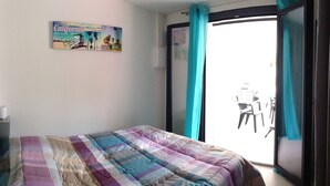 Ein Schlafzimmer mit einem Bett, einem Fenster mit Vorhängen und einer Wand mit einem Poster zum Thema Kalifornien.