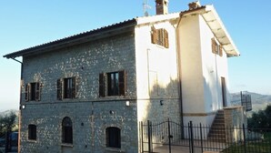Un bâtiment en pierre de deux étages, avec une partie supérieure blanche et une partie inférieure en pierre.