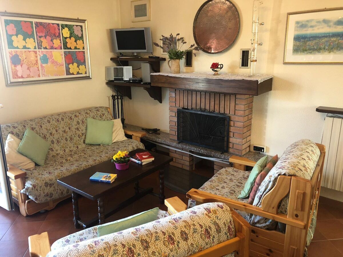 Un salon avec une cheminée, un canapé, un fauteuil et une table basse.