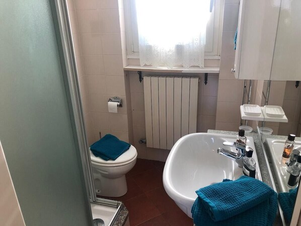 A compact bathroom with a toilet, a bathtub, and a sink.