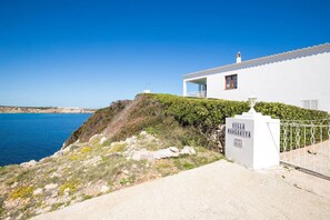 Overlooking the clear blue sea, this villa features a balcony and a well-maintained garden.