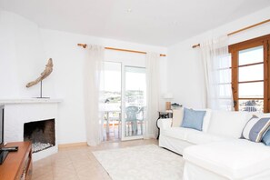 Relax in this stylish living room with a fireplace, sofa, and large window offering a view of the outdoors.