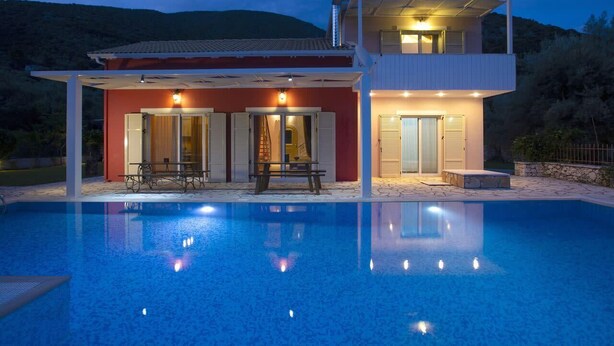 Ett modernt tvåvåningshus med en pool framför.