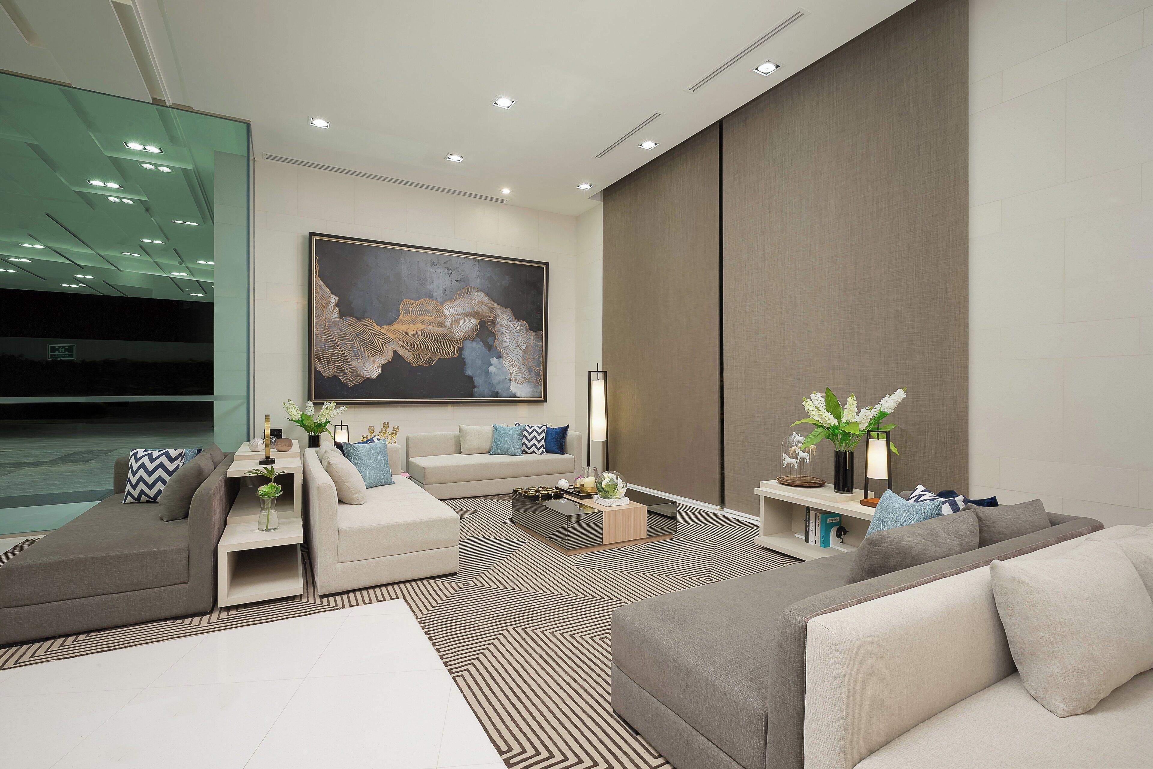 A modern living room with a sectional sofa, a coffee table, and a large abstract painting.