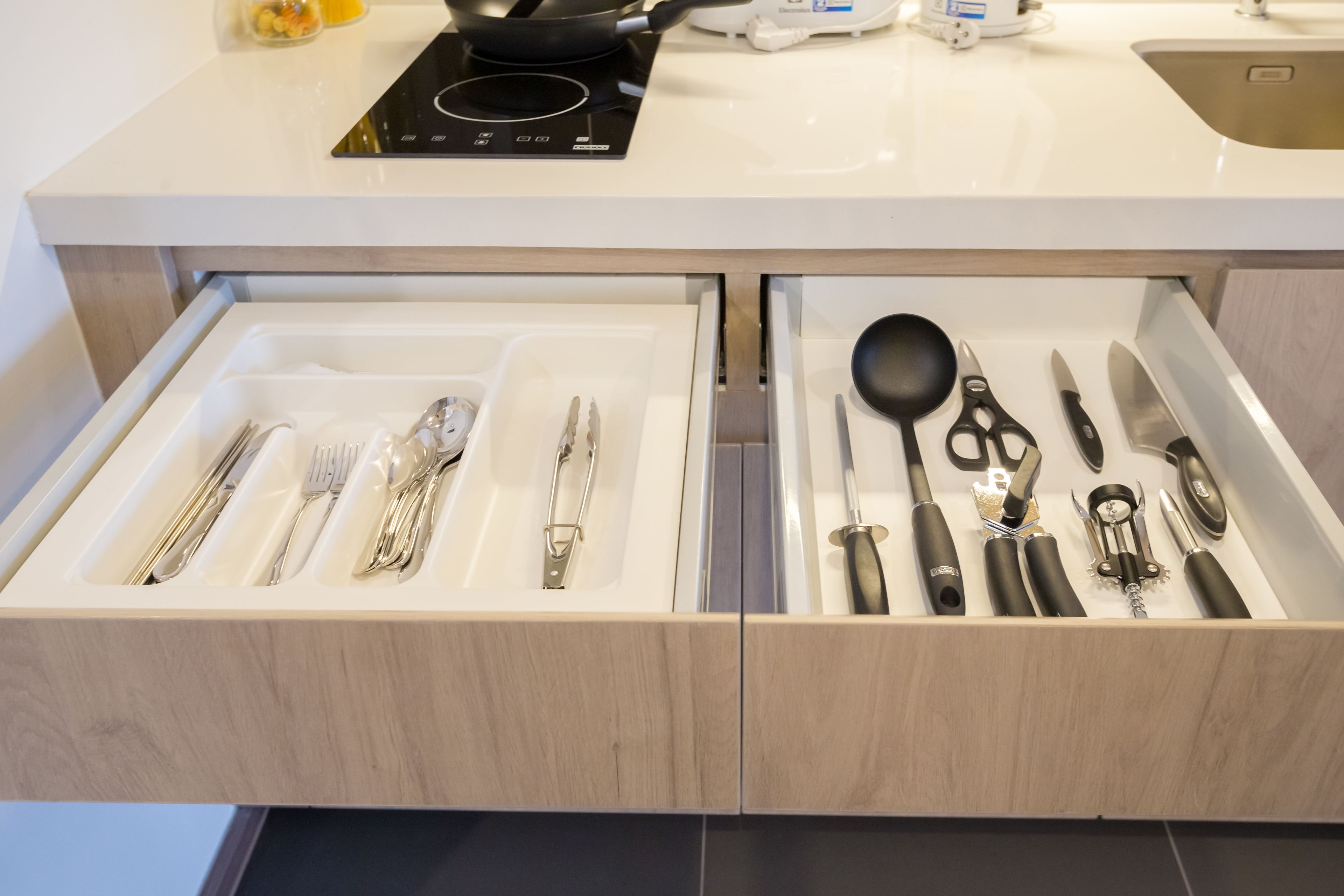 A kitchen drawer with utensils and cookware.