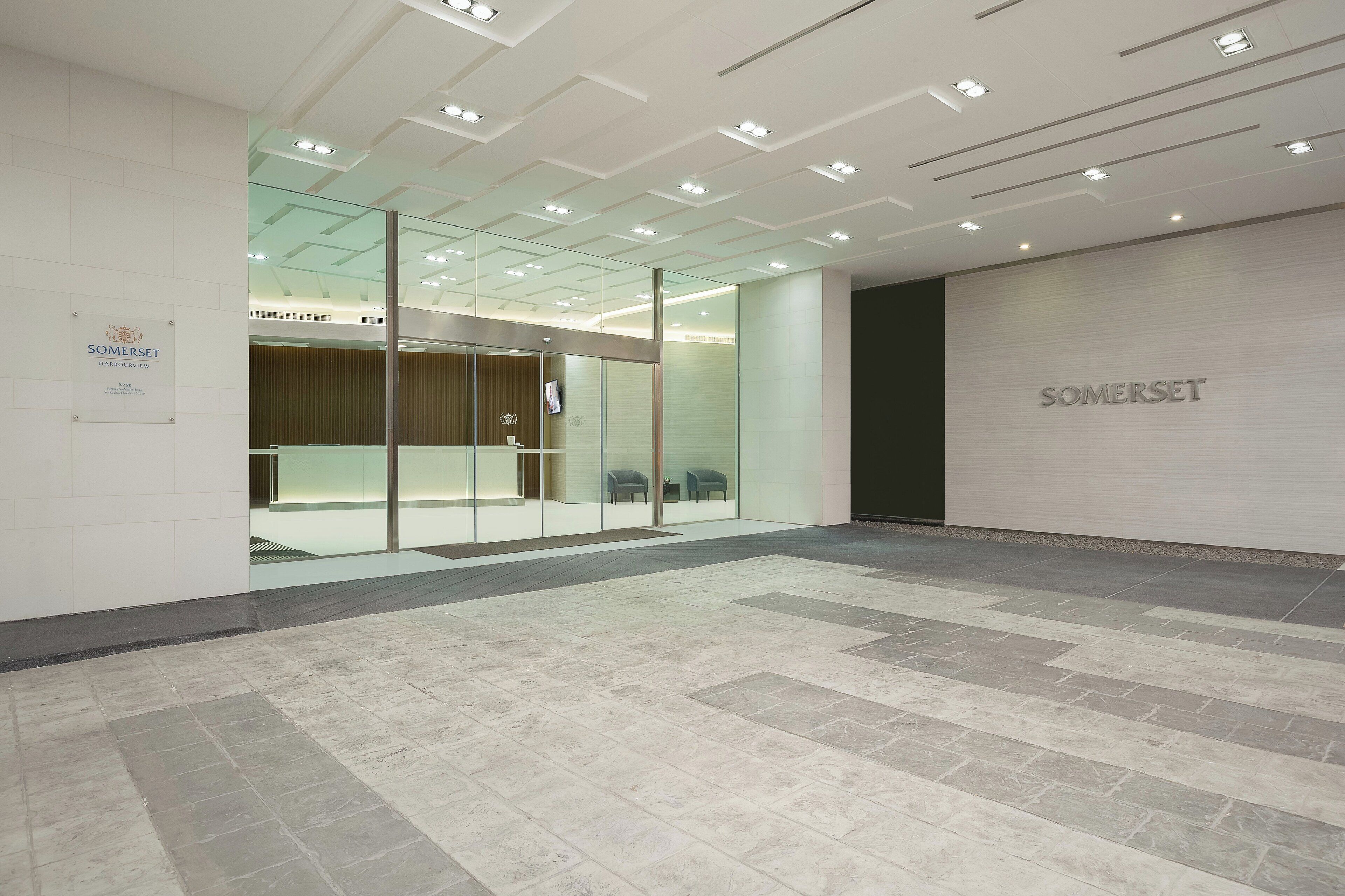 A modern interior with a reception area, glass partitions, and a tiled floor.