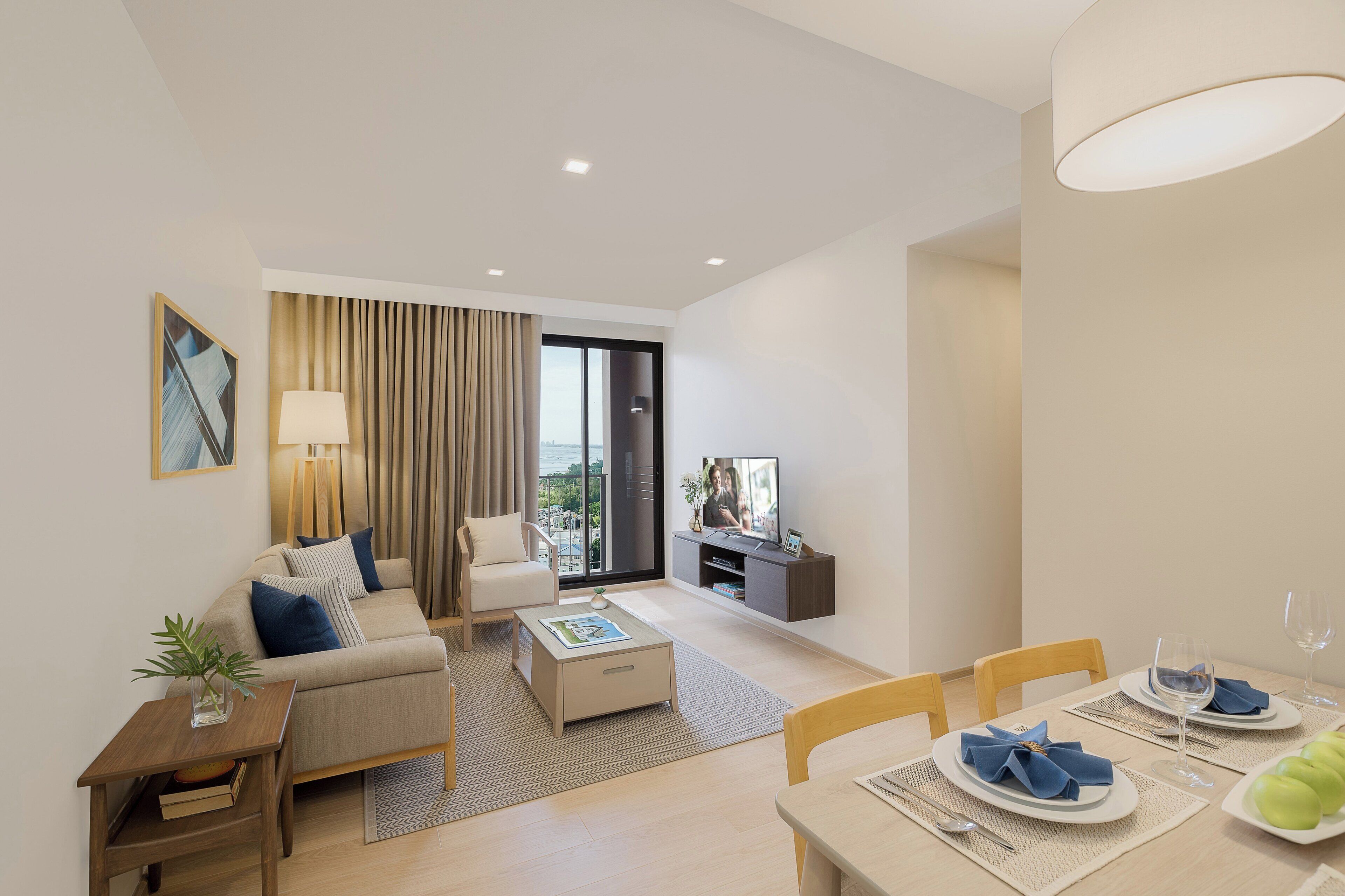 A modern living room with a sofa, coffee table, and dining area set for a meal.