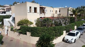 A modern residential building with a staircase, balconies, and a parking area with cars. - Casa Catalogna A, Historic Center of Lipari (Lipari)