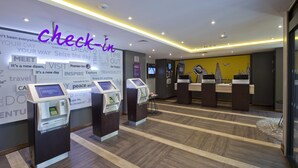 A hotel reception area with check-in kiosks, a reception desk, and a wall with motivational quotes. - Premier Inn London Farringdon - Smithfield (London)