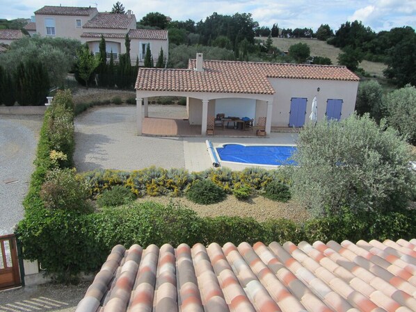 Une villa dotée d’une piscine, d’un espace salon extérieur et d’une terrasse couverte.