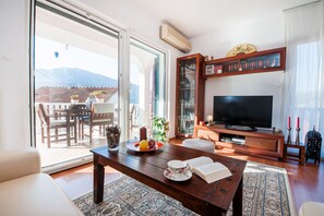 Relax in this inviting living room with a sofa, dining table, and TV, perfect for unwinding and socializing.