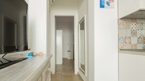 Una cucina con TV a schermo piatto, un piano di lavoro in legno e piastrelle a parete.