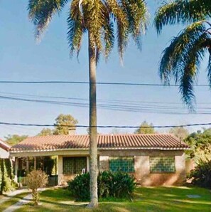 Surrounded by a lush lawn and mature trees, this single-story home offers a serene retreat.