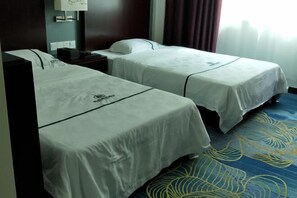 Two single beds with white linens, a nightstand, a lamp, and a patterned carpet. - Ming Tien Inn (Fengkai)